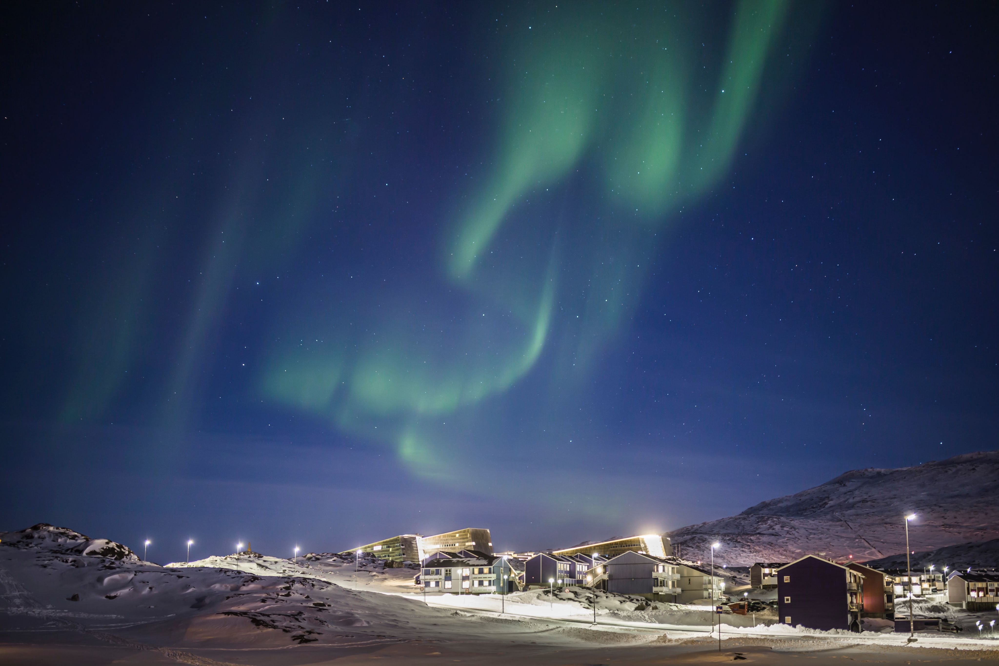 white and brown houses under green sky during night time